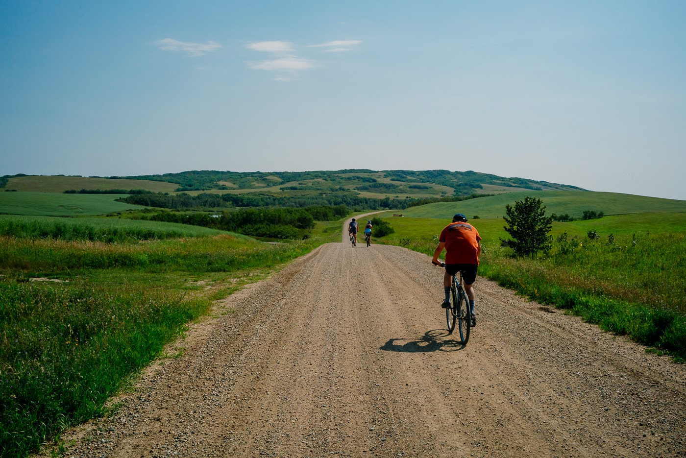Man riding bike down dirt road in Saskatchewan.